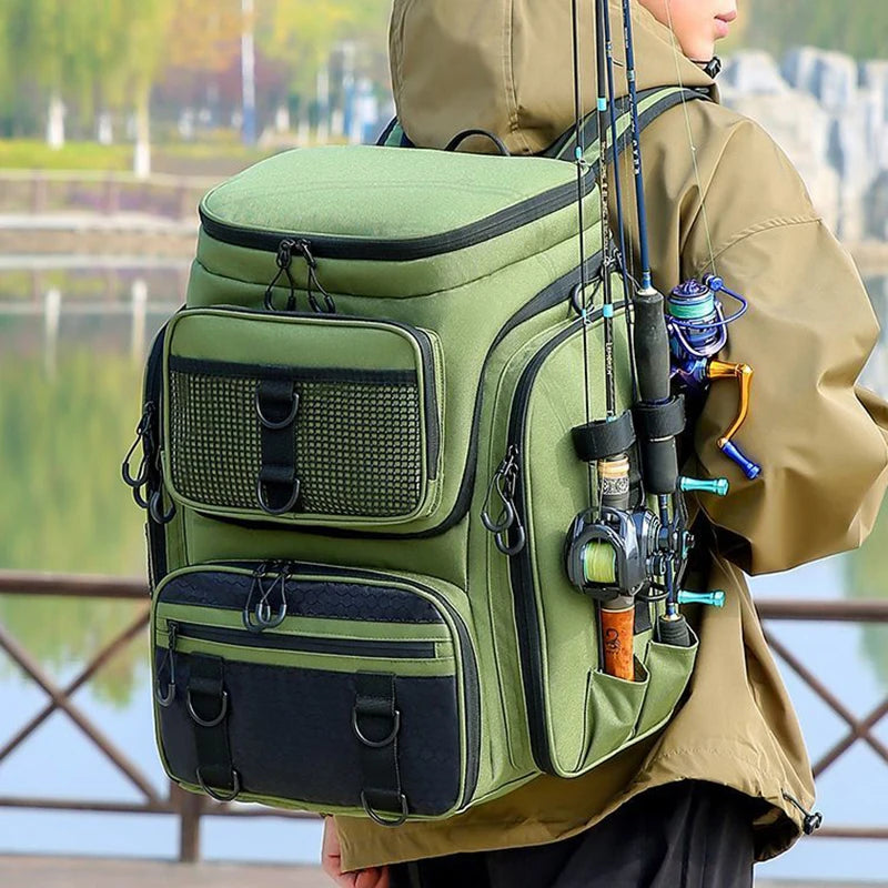 Person wearing a green fishing backpack with rods and tackle near a body of water.